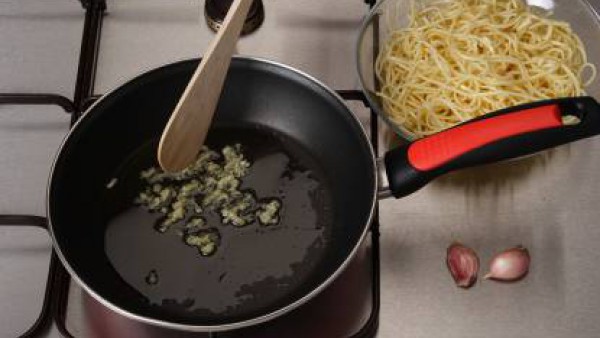 Hierve los espaguetis tal como se indica en el envase.  Escurre y rocíalos con un poco de aceite. Mientras, sofríe los ajos en una sartén con seis cucharadas de aceite.