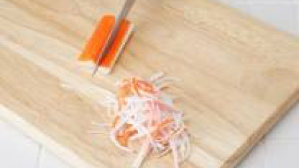 Desmenuza los palitos de cangrejo, en tiras finas como si fuesen espaguetis pequeños.
