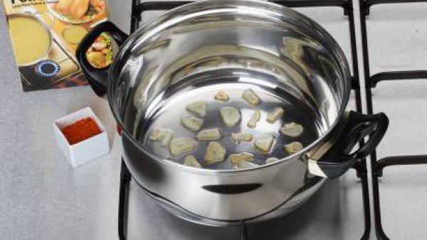 En una sartén, calienta un poco de aceite y unos ajos fileteados, rehoga y echa por encima de la merluza.