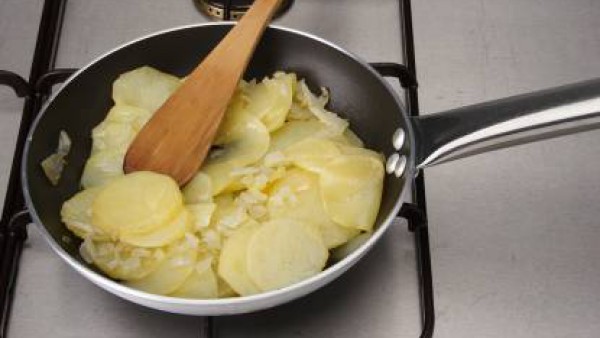 Pela las patatas y córtalas redondas. Corta la cebolla y los pimientos en cuadritos.  Fríe todo en una sartén con aceite de oliva. Cuando esté a medio freír, pon las patatas y fríelas hasta que estén 