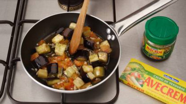 Deja que se cocine la verdura. Calienta 2 cucharadas de aceite y añadir la mitad del tomate y la berenjena. Sazona con Avecrem Verduras -30% de sal.  Tápalo y cocínalo durante 5 minutos. Cuece 5 minut