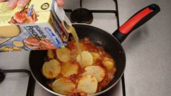 Añade los pimientos asados, las patatas a ruedas y el caldo, cuece unos 15 minutos.