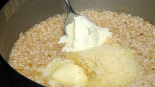 Cuando el arroz esté consumido, aparta del fuego y añade el resto de la mantequilla, la nata líquida y el parmesano. Remueve y sirve caliente.