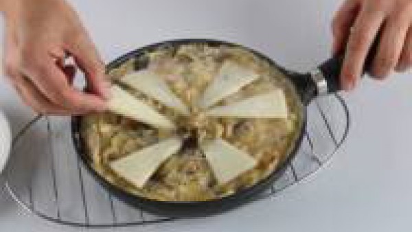 Añade el queso cortado en cuñas finas por toda la superficie de la tortilla y dale la vuelta con la ayuda de un plato llano. Deja que se termine de cocer la tortilla y sírvela aun caliente.