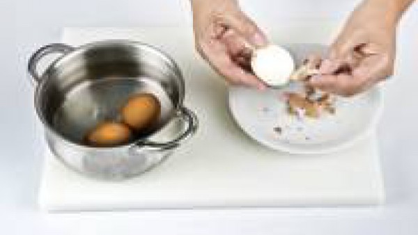Pon los huevos en el agua hirviendo y deja que cuezan durante 10 min. Luego escúrrelos, enfríalos bajo el grifo de agua fría y pélalos con cuidado. Córtalos por la mitad y separa la clara de la yema.