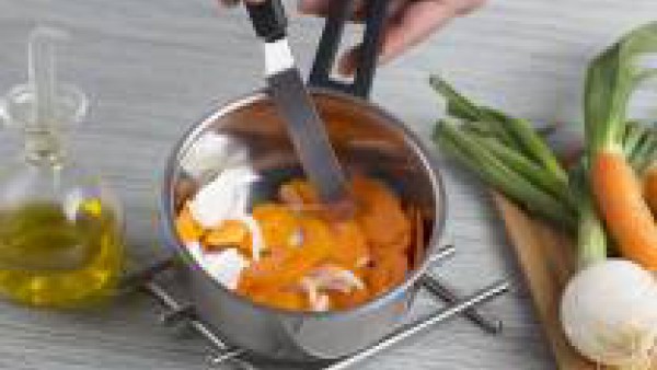 Pela y corta la zanahoria en rodajas finas y añádelas al sofrito de cebolla, deja que se ablanden unos 5 minutos, añade el Caldo Casero Suave de Pollo Gallina Blanca, la cúrcuma, el comino y deja coce