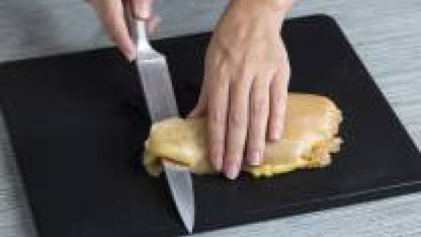 Abre las pechugas de pollo por la mitad y rellénalas con una loncha de queso, una lámina de jamón y unas tiras de pimiento rojo asado. Salpimienta y ata las pechugas de pollo con la ayuda del hilo de 