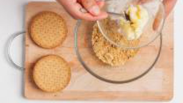 Añade la mantequilla a temperatura ambiente a las galletas aplastadas.   Mezcla y trabaja los ingredientes para crear una masa homogénea.
