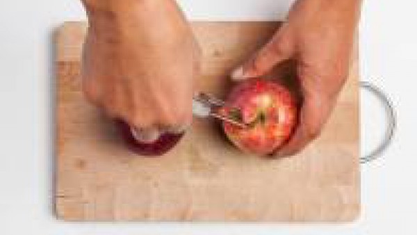 Lava las manzanas, retira su corazón y practica agujeros en la superficie de la fruta. Trocea una porción del chocolate negro (aproximadamente 100 g).