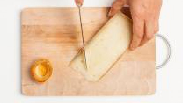 Corta el queso Emental o Gruyère en trozos de tamaño mediano. Mientras tanto, deja que el horno se caliente a 200°C.