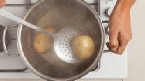 Lava y cocina las patatas en abundante agua con sal. Una vez cocidas, deja enfriar y luego pélalas.