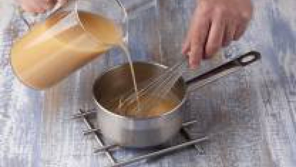 Prepara la crema de marisco, para ello echa en un cazo la mantequilla y deja que se funda, añade la harina de golpe y déjala cocinar un minuto. Echa el Caldo para Fideuá Fácil 100% Natural Gallina Bla