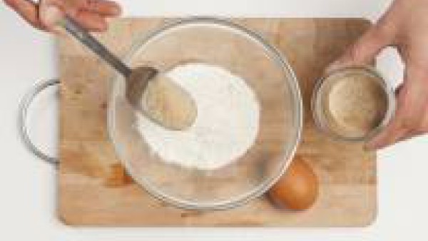 En un bol, mezcla la mantequilla ablandada con el azúcar moreno y los huevos, la harina, el polvo para hornear y la piel de naranja. Mézclalo hasta que la masa esté suave y homogénea.