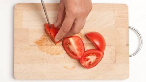 Corta los tomates lavados previamente.