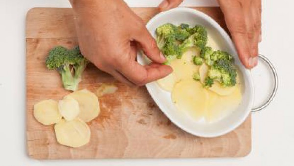 En una fuente de horno untada con un poco de aceite de oliva virgen extra pon una primera capa de patatas, a continuación, cubre con una capa de brócoli y cierra con una segunda capa de patatas.