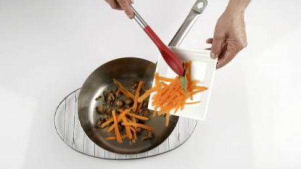 Corta la zanahoria en tiras muy delgadas, añádelas a los champiñones, junto con la hoja de laurel y una pizca de sal.