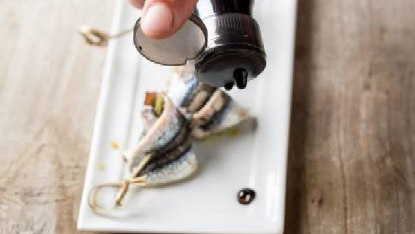 Abre las anchoas y rellena cada una con 1 cucharadita de relleno. Pincha las anchoas con palitos de madera para que no se separen las partes. Dispon las brochetas en una bandeja para hornear. Rocía co