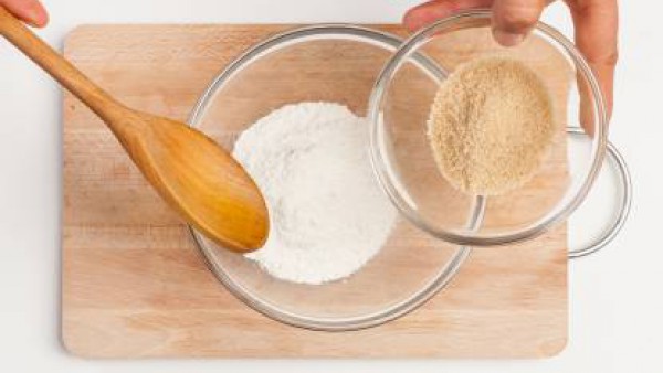 En un bol, coloca la harina, vierte el azúcar, añade los huevos y la mantequilla derretida. Remueve bien la mezcla y agrega la ralladura de la naranja y 1 taza de manzanilla.
