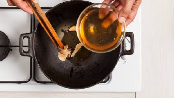 Dora en un wok el diente de ajo con una cucharada de aceite de oliva y añade las setas hidratadas.  